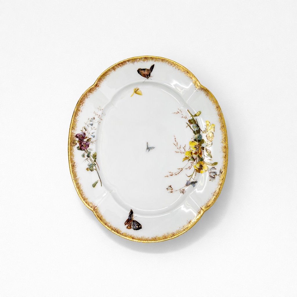 plat ovale en porcelaine Limoges William Guerin & Cie à décor de fleurs polychromes et papillon liseré doré L 35,6 x P 28 cm