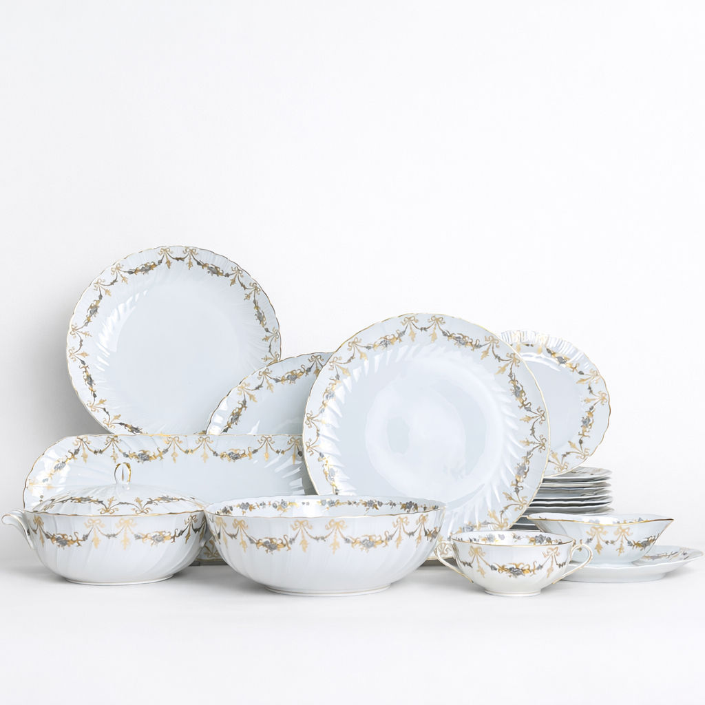 plat ovale en porcelaine Bernardaud modèle Marie-Thérèse fond blanc décor doré et argenté noeuds et guirlandes L 33 x L 25,5 cm