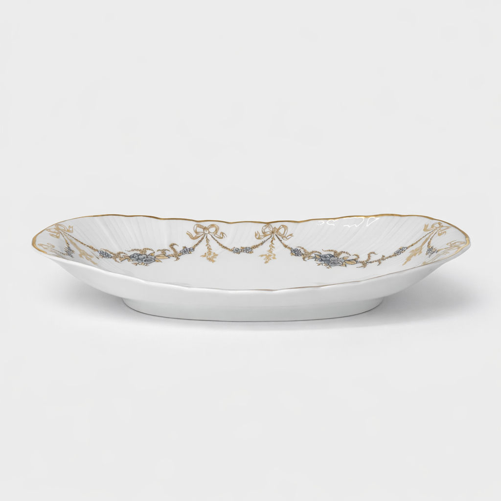 ravier en porcelaine Bernardaud modèle Marie-Thérèse fond blanc décor doré et argenté noeuds et guirlandes L 23 x P 12 cm