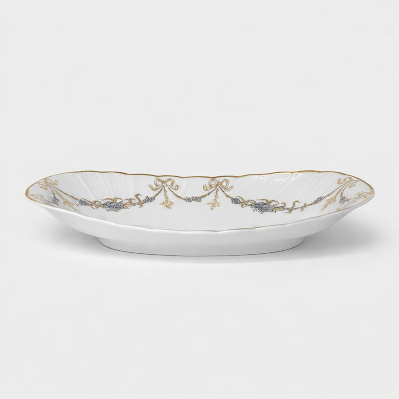 ravier en porcelaine Bernardaud modèle Marie-Thérèse fond blanc décor doré et argenté noeuds et guirlandes L 23 x P 12 cm